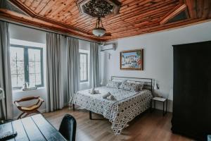 sypialnia z łóżkiem i drewnianym sufitem w obiekcie Atelier Boutique Hotel w Szkodrze