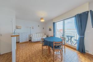 a living room with a table and a balcony at Résidence Clemenceau 1 in Royan