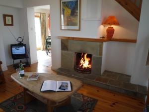 sala de estar con chimenea y mesa con libro en Achill Sound HV No 7 en Achill Sound