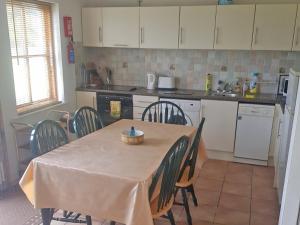 a kitchen with a table and chairs and a kitchen with white cabinets at Achill Sound HV No 7 in Achill Sound