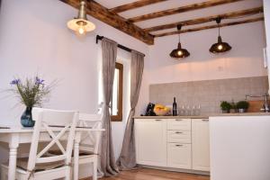 uma cozinha com armários brancos e uma mesa e cadeiras em Bruno Old town apartments em Rovinj