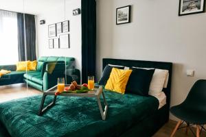 ein Wohnzimmer mit einem Sofa mit einem Tisch und Obst darauf in der Unterkunft EASY RENT Apartments - Diamond in Lublin