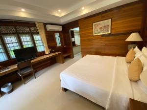 a bedroom with a bed and a desk and a television at Smile House - Fisherman Village in Bophut
