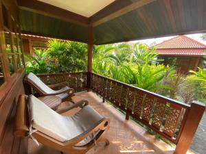 two chairs sitting on a porch with trees at Smile House - Fisherman Village in Bophut