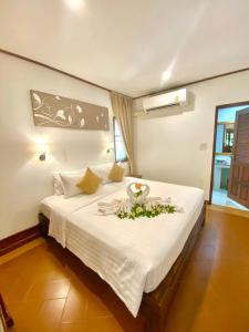 a bedroom with a large white bed with flowers on it at Smile House - Fisherman Village in Bophut +37 photos