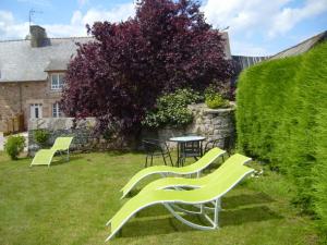 two green chairs and a table in a yard at Maison Le Chatelet in Erquy