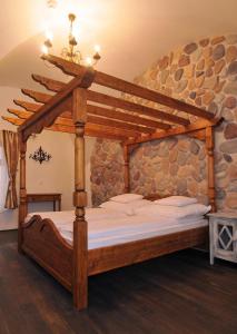 a bedroom with a wooden bed in a stone wall at Régi Posta Étterem és Fogadó in Debrecen