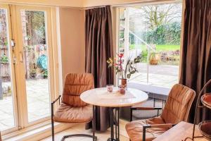 een kamer met een tafel en stoelen en een raam bij Verborgen Parel aan de Rotte in Rotterdam