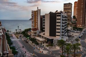 a city street with buildings and the ocean at Hotel Golden in Benidorm