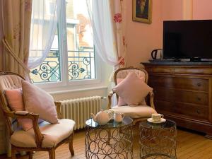a living room with two chairs and a table and a window at Enclos de l'Evêché in Boulogne-sur-Mer