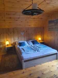 een slaapkamer met een bed in een houten plafond bij Agroturystyka Pod Pstrągiem in Lipnica