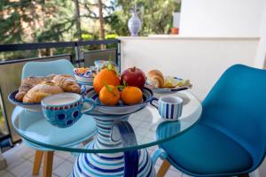 a glass table with bowls of fruit and pastries on it at Aquae Romanae Piazza Lauro in Sorrento