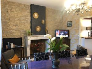 a living room with a table and a fireplace at Le Clos Des Lys in Saint-Georges-dʼOléron