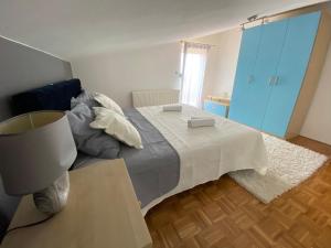 sypialnia z łóżkiem ze stołem i niebieskimi szafkami w obiekcie Casa Duje w mieście Zadar