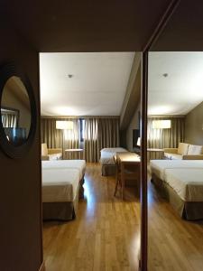 a hotel room with two beds and a television at Parador De La Seu D'urgell in La Seu d'Urgell