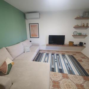 a living room with a couch and a tv at Central Home Away From Home in Shkodër