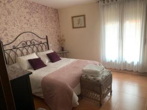 a bedroom with a large bed with purple pillows at La Luna in Aldeanueva del Camino
