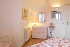 a bedroom with a bed and a dresser with a lamp at Villa Armonia - Nel cuore della Costa Smeralda in Abbiadori