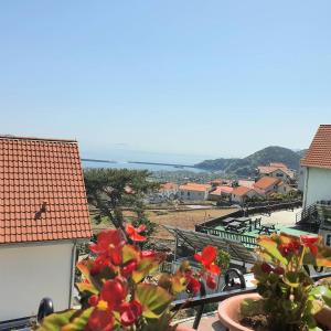 a balcony with a view of the ocean and buildings at Namhae Manheim pension in Namhae