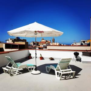 two chairs and an umbrella on a roof at Apartment in the center in Terrasini