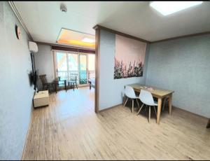 a room with a table and chairs in a room at Namhae Manheim pension in Namhae
