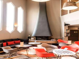 a living room with tables and chairs and a fireplace at ibis Château-Thierry in Essômes-sur-Marne