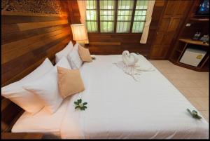 a large bed with white sheets and flowers on it at Smile House - Fisherman Village in Bophut