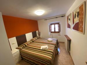 a bedroom with a bed with a striped blanket at Casa Murillo in Boltaña