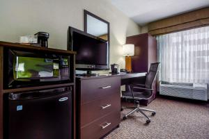 グランドアイランドにあるSleep Inn By Choice Hotelsのデスク、テレビ、コンピュータが備わる客室です。