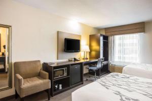 Una habitación de hotel con una cama y un escritorio con televisión. en Sleep Inn Kansas City International Airport, en Kansas City