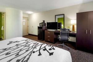 a hotel room with a bed and a desk and a computer at Sleep Inn By Choice Hotels in Grand Island