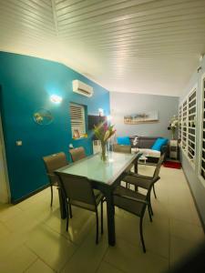a dining room with a table and chairs and a couch at Maelya House in Sainte-Anne +23 photos