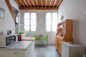a kitchen with white walls and a wooden ceiling at Ludovica Studio - Backpackers House Vernazza in Vernazza
