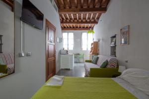 a bedroom with a green bed and a couch at Ludovica Studio - Backpackers House Vernazza in Vernazza