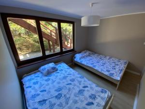 a small room with two beds and a window at Dom przy lesie. Ostrowo in Ostrowo