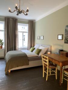 Schlafzimmer mit einem Bett, einem Schreibtisch und einem Tisch in der Unterkunft Ferienwohnung HIRZELZEIT in Leipzig
