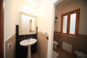 a bathroom with a sink and a mirror and a toilet at La Casa dei Venti - Aeolian Charme in Canneto
