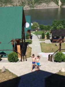 twee mensen die naast elkaar staan voor een speeltuin bij Family House in Makarovka