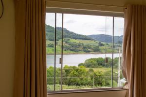 a window with a view of a lake and mountains at Apartamento em Marcelino Ramos ao lado das Termas in Belém Velho