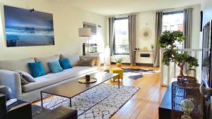 a living room with a couch and a table at LESPARISNORMANDS - le duplex de la reine in Boulogne-Billancourt