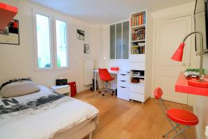 a bedroom with a bed and a desk and chairs at LESPARISNORMANDS - le duplex de la reine in Boulogne-Billancourt