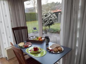 une table bleue avec de la nourriture et une fenêtre dans l'établissement B&B 't Gezellig Huizeke, à Zoersel