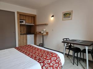 a room with a bed and a table and a kitchen at Le Moulin du Verdon in Gréoux-les-Bains