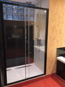 a shower with glass doors in a room at Les voiles rouges in Saint-Martin-de-Ré