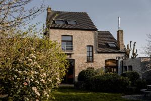 a brick house with a black roof at Villa Ghysbrecht in Alveringem