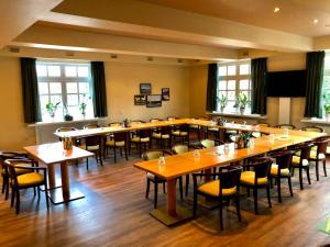 a large room with tables and chairs and windows at Gasthaus Block in Harkebrügge