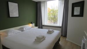 een slaapkamer met een bed met twee handdoeken erop bij Hotel Marktzicht in Harderwijk