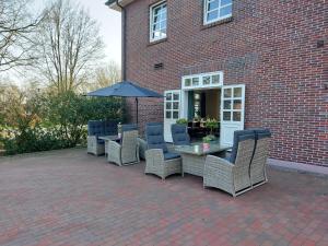 un patio con mesa, sillas y sombrilla en Gasthaus Block en Harkebrügge