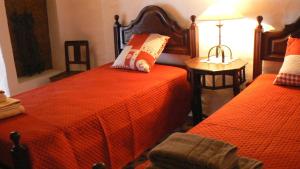 una camera da letto con due letti e un tavolo con una lampada di Casa da Tia Maria By Alojamentos Vitinho a São Luis