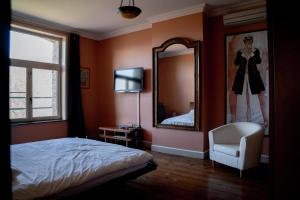 una camera con letto, specchio e sedia di Villa Ghysbrecht ad Alveringem